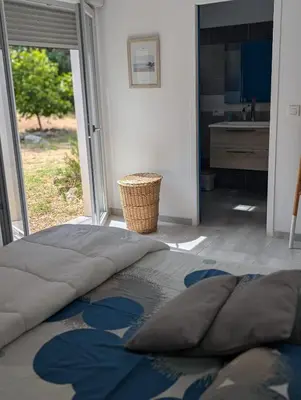 a bedroom with a large bed and a kitchen at Maison climatisée de 3 chambres avec piscine privée in Sotta