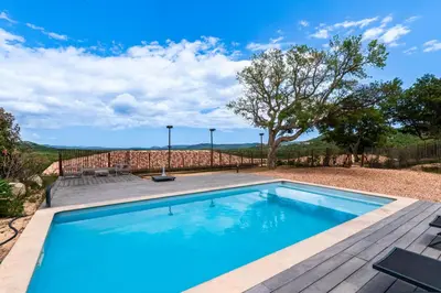 a swimming pool with a wooden deck next to at Maison Mawie - Vue montagne piscine jacuzzi in Sotta