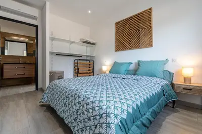 a bedroom with a bed with a blue comforter at Maison Mawie - Vue montagne piscine jacuzzi in Sotta