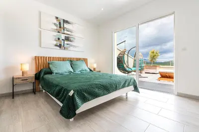 a bedroom with a bed and a view of the ocean at Maison Mawie - Vue montagne piscine jacuzzi in Sotta