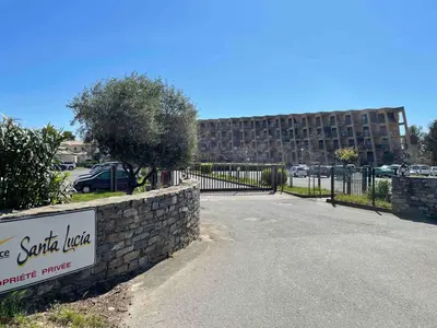 a sign in front of a stone wall with a building at Studio vue Mer 4 personnes climatisé in Santa-Lucia-di-Moriani