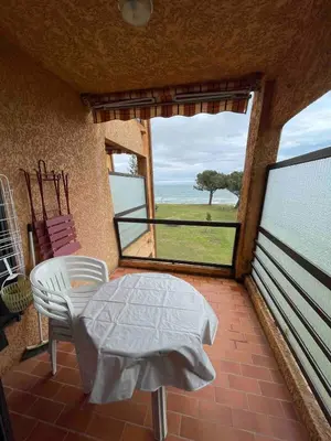 a balcony with a table and a view of the ocean at Studio vue Mer 4 personnes climatisé in Santa-Lucia-di-Moriani