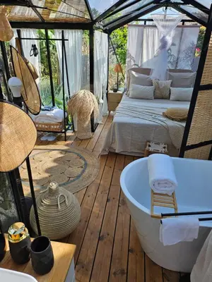 a bathroom with a tub and a bed in a tent at L orangerie de casaoma in Prunelli-di-Fiumorbo