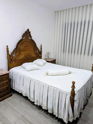 a bedroom with a large wooden bed with white sheets at Sguard'Alba by vBOAS in Propriano