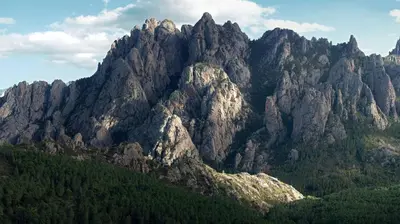 a large rocky mountain with trees in front of it at Le Cabanon by Pinarello Villa Services in Zonza