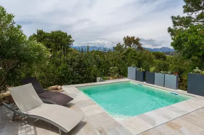 a swimming pool with a chair and a chair at Le Cabanon by Pinarello Villa Services in Zonza