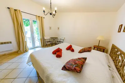 a bedroom with a bed with red pillows on it at Le Cabanon by Pinarello Villa Services in Zonza