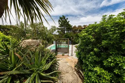 a gate in the middle of a garden with plants at Le Cabanon by Pinarello Villa Services in Zonza