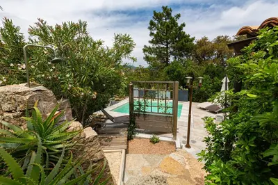 a pool with a chair in a garden at Le Cabanon by Pinarello Villa Services in Zonza