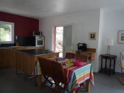 a kitchen with a table with a colorful table cloth at Canopee by Pinarello Villa Services in Zonza