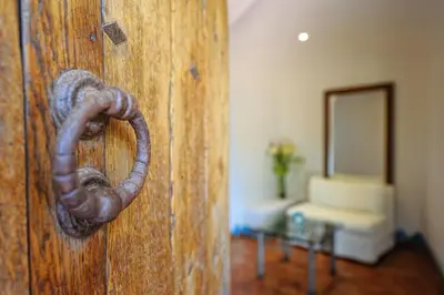 a wooden door with a rusty ring on it at Hôtel Marina di cavu in Bonifacio