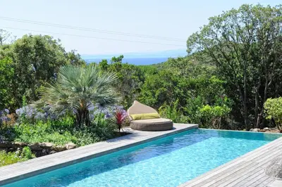a swimming pool with a view of the ocean at Hôtel Marina di cavu in Bonifacio