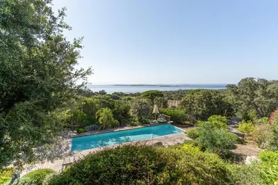 an aerial view of a swimming pool with the ocean in the background at Hôtel Marina di cavu in Bonifacio