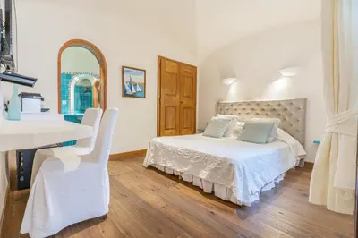 a bedroom with a bed and a sink and a mirror at Hôtel Marina di cavu in Bonifacio