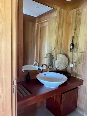 a bathroom with a sink and a large mirror at Villa Lavezzi in Bonifacio