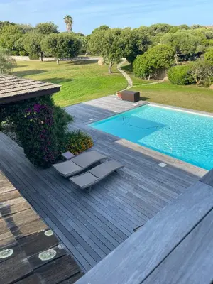 a deck with two lounge chairs next to a swimming pool at Villa Lavezzi in Bonifacio