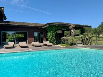 a swimming pool with chairs and a house at Villa Lavezzi in Bonifacio