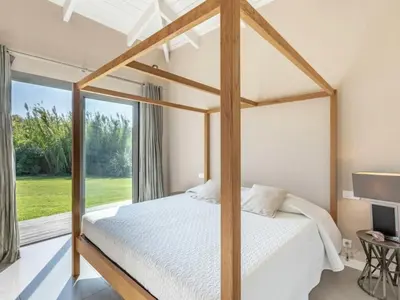 a bedroom with a canopy bed and a large window at Villa Lavezzi in Bonifacio