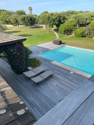 a deck with two lounge chairs next to a swimming pool at Villa Lavezzi in Bonifacio