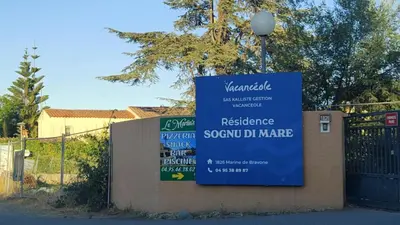 a sign on a fence in front of a building at Appartamento climatizzato di 42 mq a Marina di Bravone a 200m dalla spiaggia in Linguizzetta