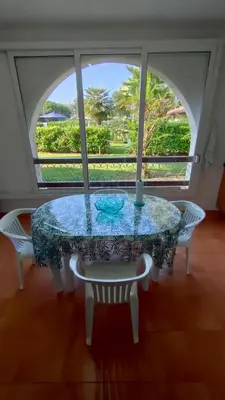 a glass table with two chairs and a window at Appartamento climatizzato di 42 mq a Marina di Bravone a 200m dalla spiaggia in Linguizzetta
