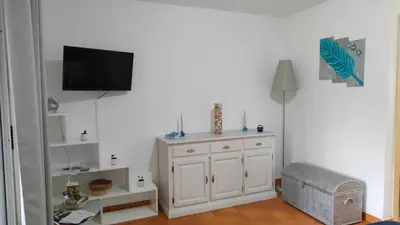 a room with a white cabinet and a tv on a wall at Appartamento climatizzato di 42 mq a Marina di Bravone a 200m dalla spiaggia in Linguizzetta