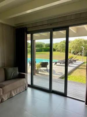 a living room with sliding glass doors leading to a patio at Apartments PETIT DOMAIN DE SPERONE in Bonifacio