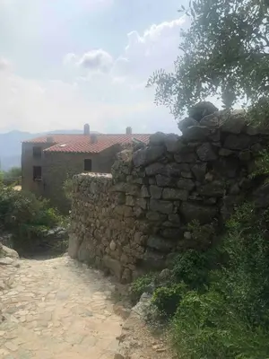 a stone wall in front of a building at Historic Villa In Sant Antonino With Sea Views in SantʼAntonino