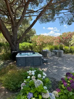 a hot tub in a garden with flowers at Casa Flamingo in Porto-Vecchio