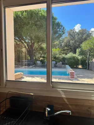 a kitchen window with a view of a swimming pool at Casa Flamingo in Porto-Vecchio