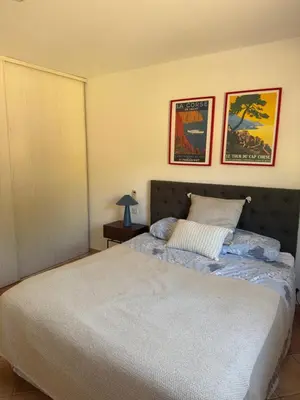 a bedroom with a bed and two pictures on the wall at Casa Flamingo in Porto-Vecchio