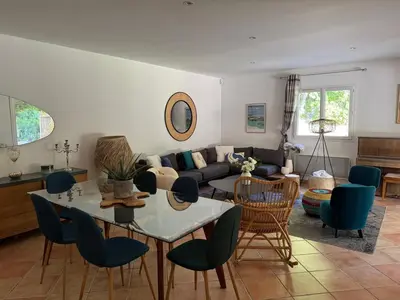 a living room with a couch and a table and chairs at Casa Flamingo in Porto-Vecchio