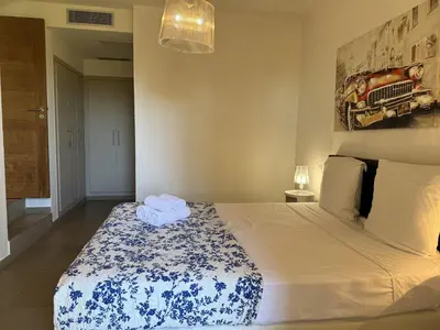 a bedroom with a bed with a blue and white blanket at T4 Cote Plage N6 face a la mer in Pinarellu