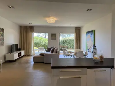 a kitchen and living room with a couch and a table at T4 Cote Plage N6 face a la mer in Pinarellu