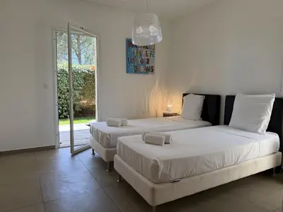 a bedroom with two beds and a window at T4 Cote Plage N6 face a la mer in Pinarellu