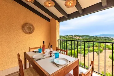 a dining table with a view of a vineyard at La Petite Felicità - Jolie Vue sur la Baie d'Ajaccio in Grosseto-Prugna