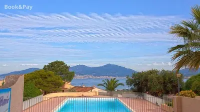 a swimming pool with a view of the ocean and mountains at La Petite Felicità - Jolie Vue sur la Baie d'Ajaccio in Grosseto-Prugna