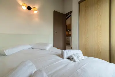 a white bed with two towels on top of it at La Petite Felicità - Jolie Vue sur la Baie d'Ajaccio in Grosseto-Prugna