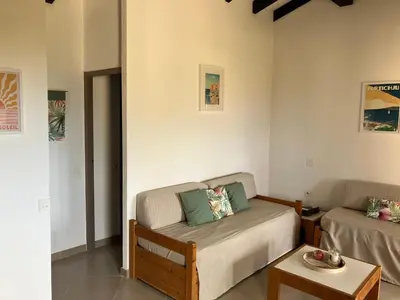 a living room with a couch and a table at La Petite Felicità - Jolie Vue sur la Baie d'Ajaccio in Grosseto-Prugna