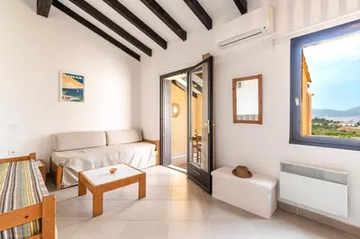 a living room with a couch and a table at La Petite Felicità - Jolie Vue sur la Baie d'Ajaccio in Grosseto-Prugna
