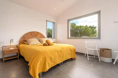 a bedroom with a bed with a teddy bear on it at La Villa Pianottoli - Magnifique Vue Panoramique in Pianottoli-Caldarello