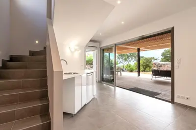 an open kitchen and staircase in a house at La Villa Pianottoli - Magnifique Vue Panoramique in Pianottoli-Caldarello