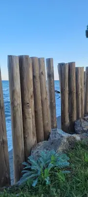 a wooden fence on the beach near the water at Santa Lucia Dream in Santa-Lucia-di-Moriani