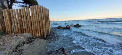 a wooden fence on the beach next to the ocean at Santa Lucia Dream in Santa-Lucia-di-Moriani