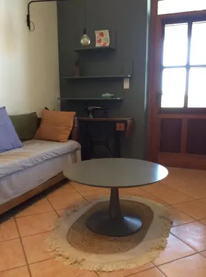 a living room with a table and a couch at La Maison De Stephanie in Porto-Vecchio