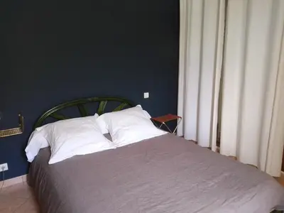 a bed with white pillows in a blue bedroom at La Maison De Stephanie in Porto-Vecchio