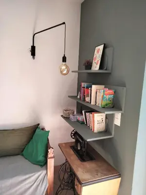 a room with a bed and a shelf with books at La Maison De Stephanie in Porto-Vecchio