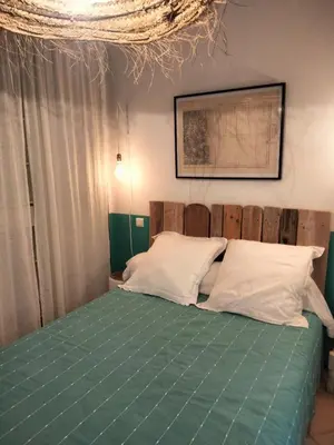 a bedroom with a bed with green sheets and white pillows at La Maison De Stephanie in Porto-Vecchio