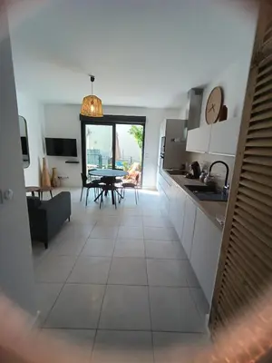 a kitchen and living room with a table and chairs at Duplex Cosy- Sérénité en Bord de Mer in Borgo