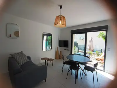 a living room with a couch and a table at Duplex Cosy- Sérénité en Bord de Mer in Borgo